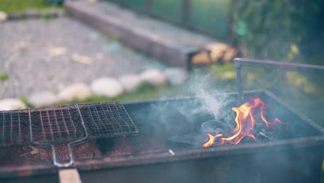 Close-up-man-prepares-the-coals-in-the-grill-stirs-them-with-a-stick