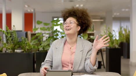 Retrato-De-Una-Mujer-De-Negocios-Birracial-Informal-En-Videollamada-En-La-Oficina,-Cámara-Lenta-Con-Espacio-Para-Copiar