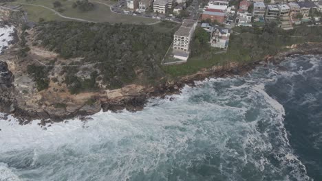 Vista-Aérea-De-La-Ciudad-De-Coogee---Olas-Del-Océano-Rompiendo-En-Los-Acantilados-Y-La-Bahía-De-Gordons---Suburbio-Costero-En-Sydney,-Nsw,-Australia