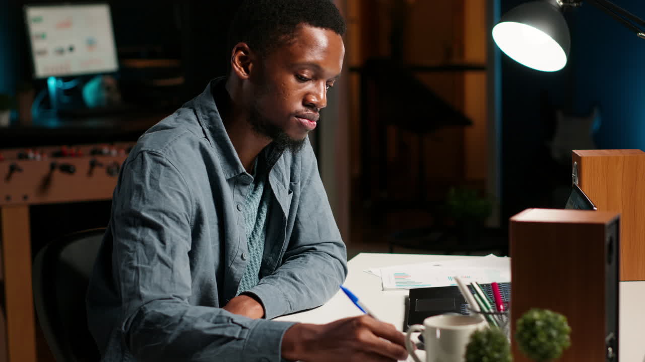 African American freelancer working from home writing notes and researching