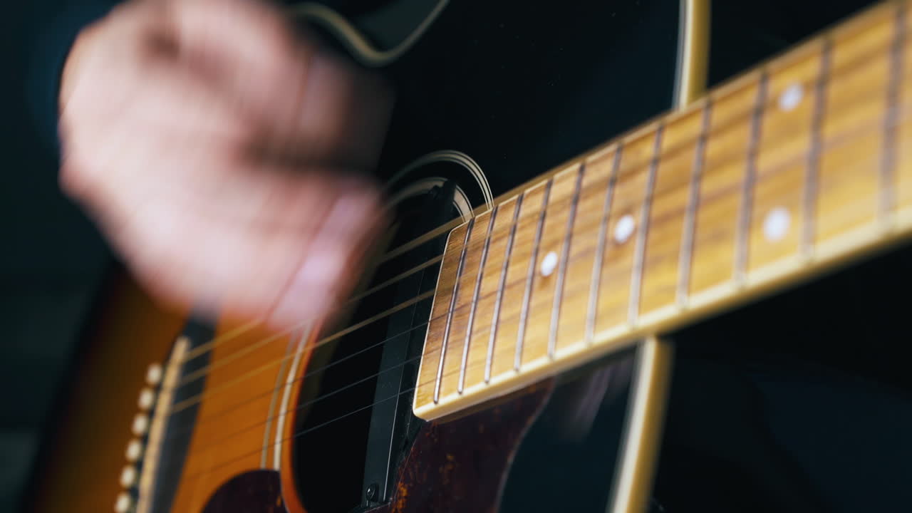 skilled musician plays acoustic guitar pressing strings