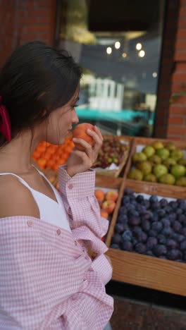 woman looking at peaches at a fruit stand