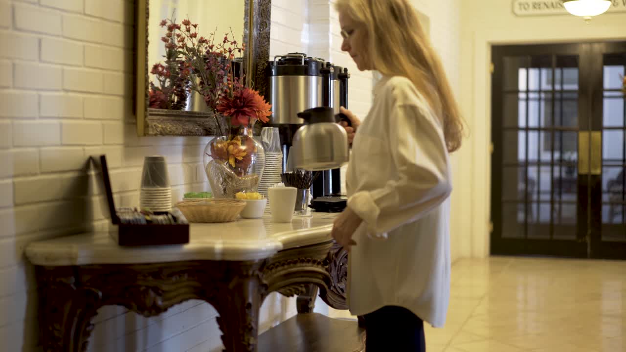 Woman pouring coffee in a hotel lobby