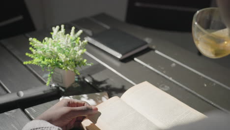 champ enjoying a quiet moment reading book at table, with tea cup in hand and potted plant beside. soft lighting illuminates peaceful indoor space, creating a serene atmosphere