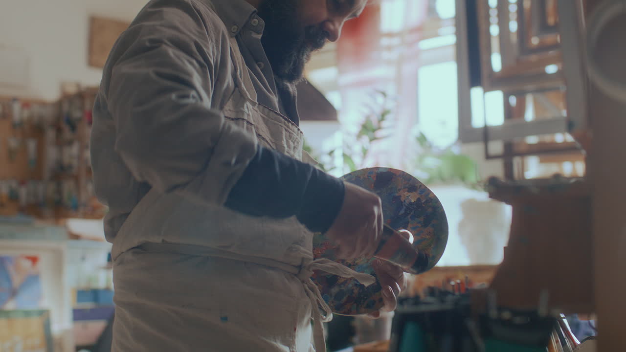 Artist Preparing Colorful Wooden Palette for Painting in Studio