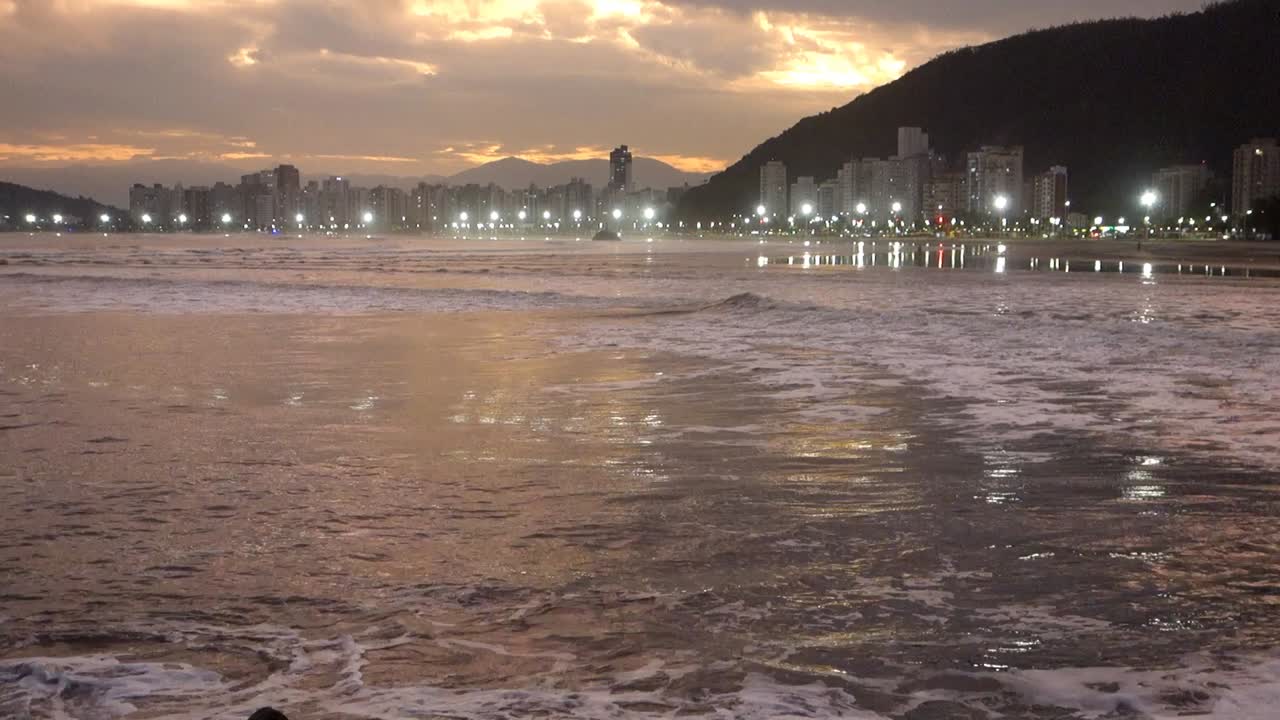 olas rompiendo en la playa de itarare en sao vicente, sp, brasil, al atardecer