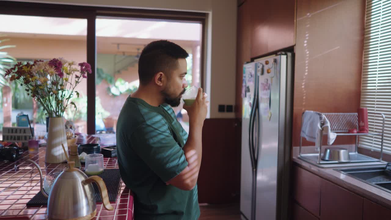 Man drinking matcha in the kitchen