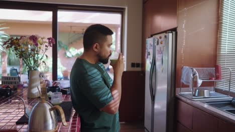 man drinking matcha in the kitchen