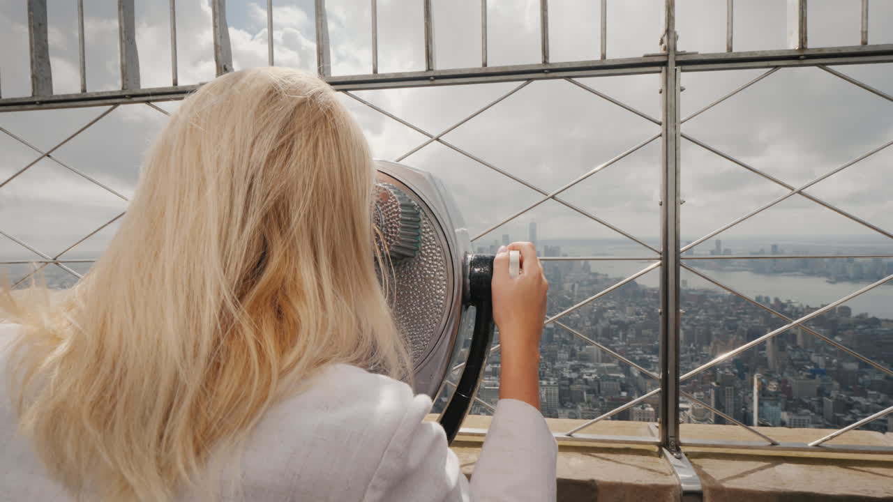 mujer rubia mirando a través de binoculares en el panorama de nueva york visite el concepto de nueva york