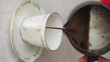 pouring turkish coffee into a delicate cup