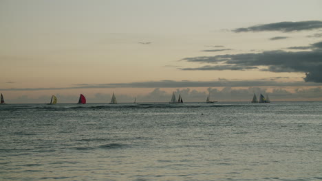 sailboats on the ocean at dusk