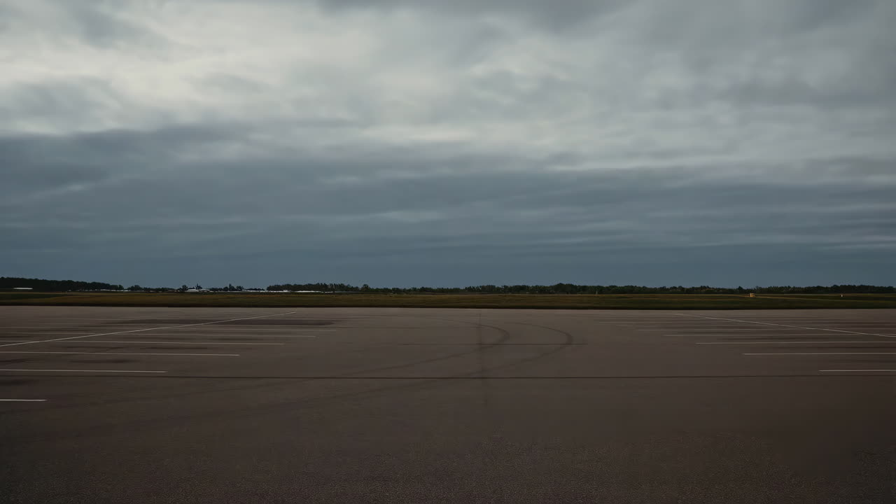 Empty asphalt parking lot under a cloudy sky