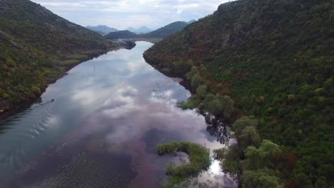 una asombrosa antena sobre un barco de pesca mientras se mueve a lo largo de un río en montenegro 3
