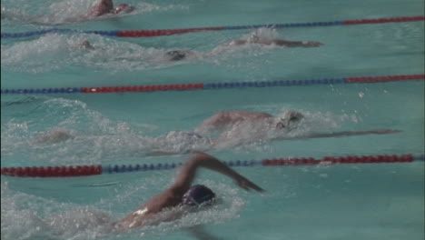 male swimmers reach the edge turn over and start swimming back