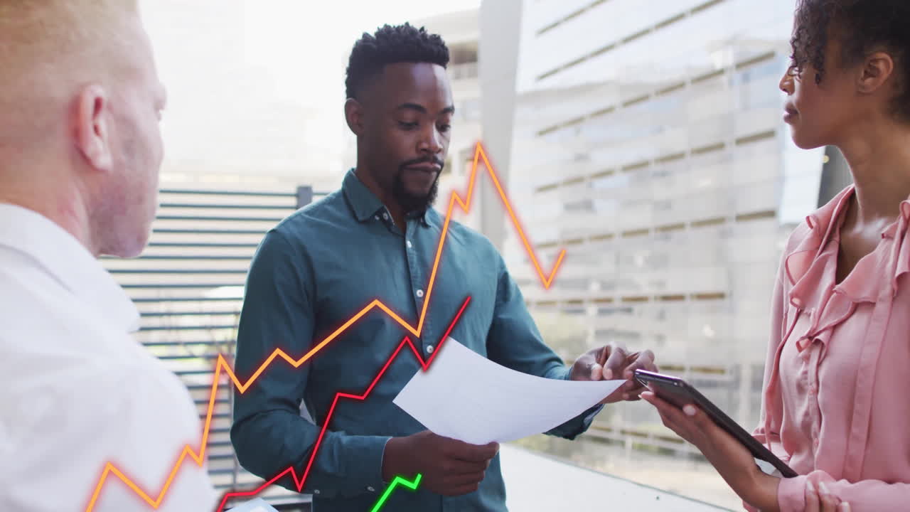 Discussing financial graphs, business professionals collaborating on documents in office