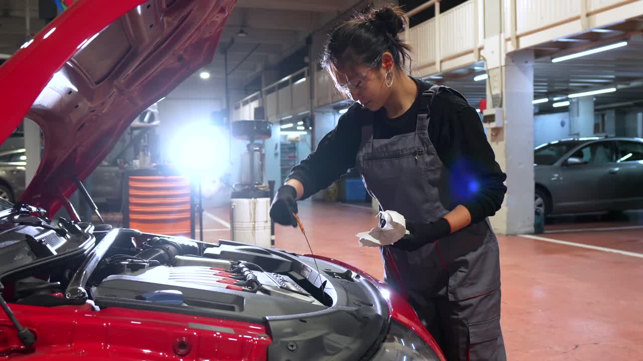 Female Mechanic Inspecting Car Engine