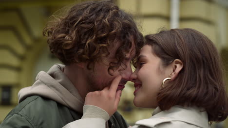 una pareja de amor sintiéndose feliz juntos. una mujer tocando la cara de un hombre en una calle urbana.