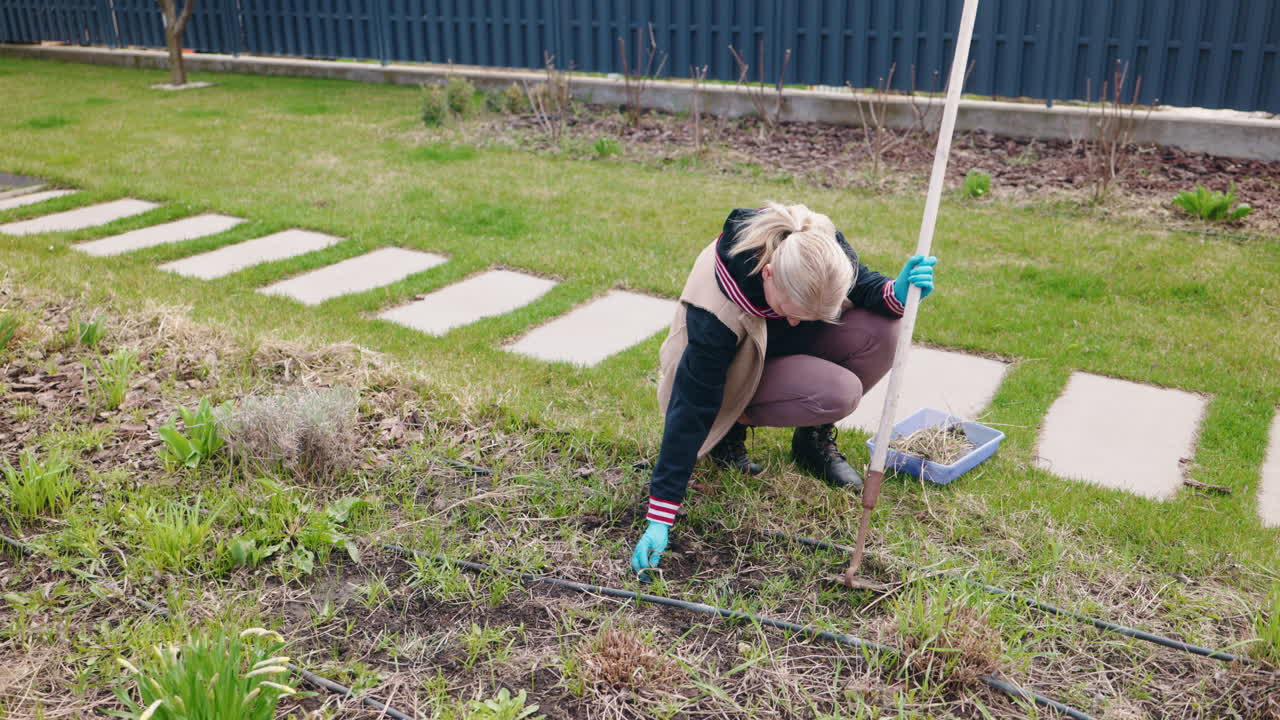 뒷마당 에서 정원 을 꾸리는 여자