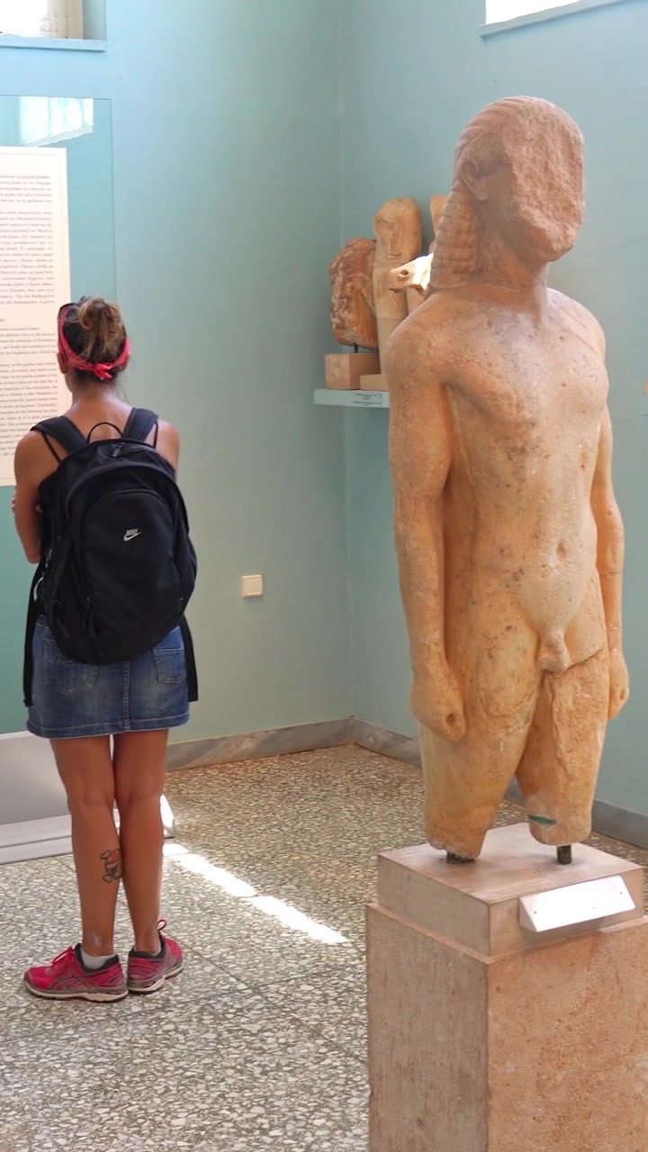 Eleusi, Grecia, 30 agosto 2019. Giovane turista che ammira antiche ceramiche greche nel museo archeologico di Eleusi.
