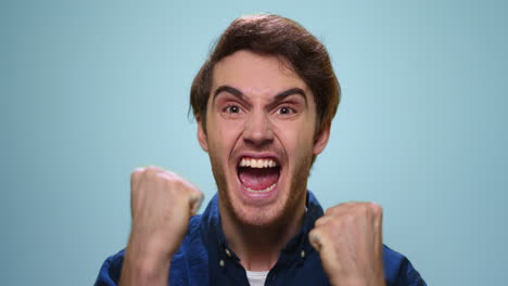 excited man celebrating success in studio. happy guy showing yes gesture