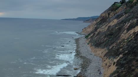 top down birds eye aerial view of the waves crashing on a rocky southern california beach