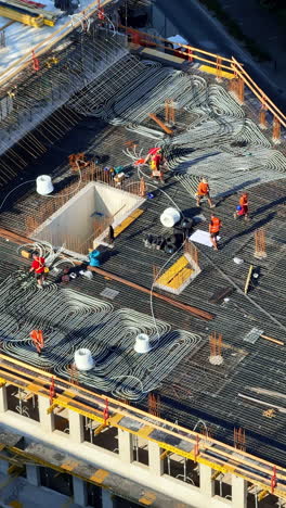 workers laying foundation. construction workers are actively preparing the roof structure at a building site during daytime with visible materials