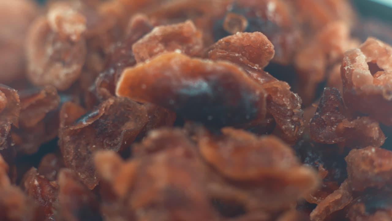 回転台の上で回るボウルに入ったドライクランベリーの山のマクロクローズアップショット、スローモーション、4K。