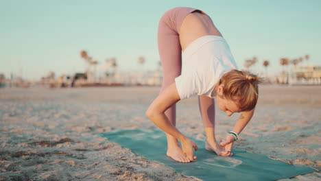 Fitness-woman-doing-yoga-on-the-beach.