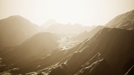 serene mountain landscape under a hazy golden light during twilight hours