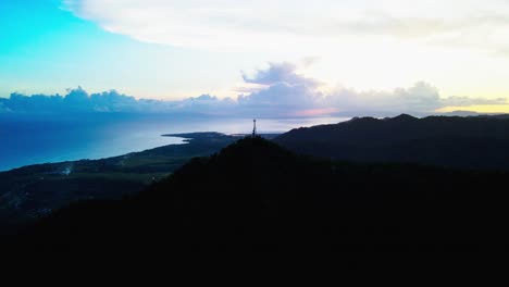 picturesque silhouette outline of lush mount cagmasuso and satellite tower with stunning, vibrant cloud background at catanduanes, bicol, philippines - aerial drone shot
