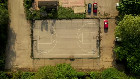 empty outdoor basketball court pan up drone shot in the neighborhood