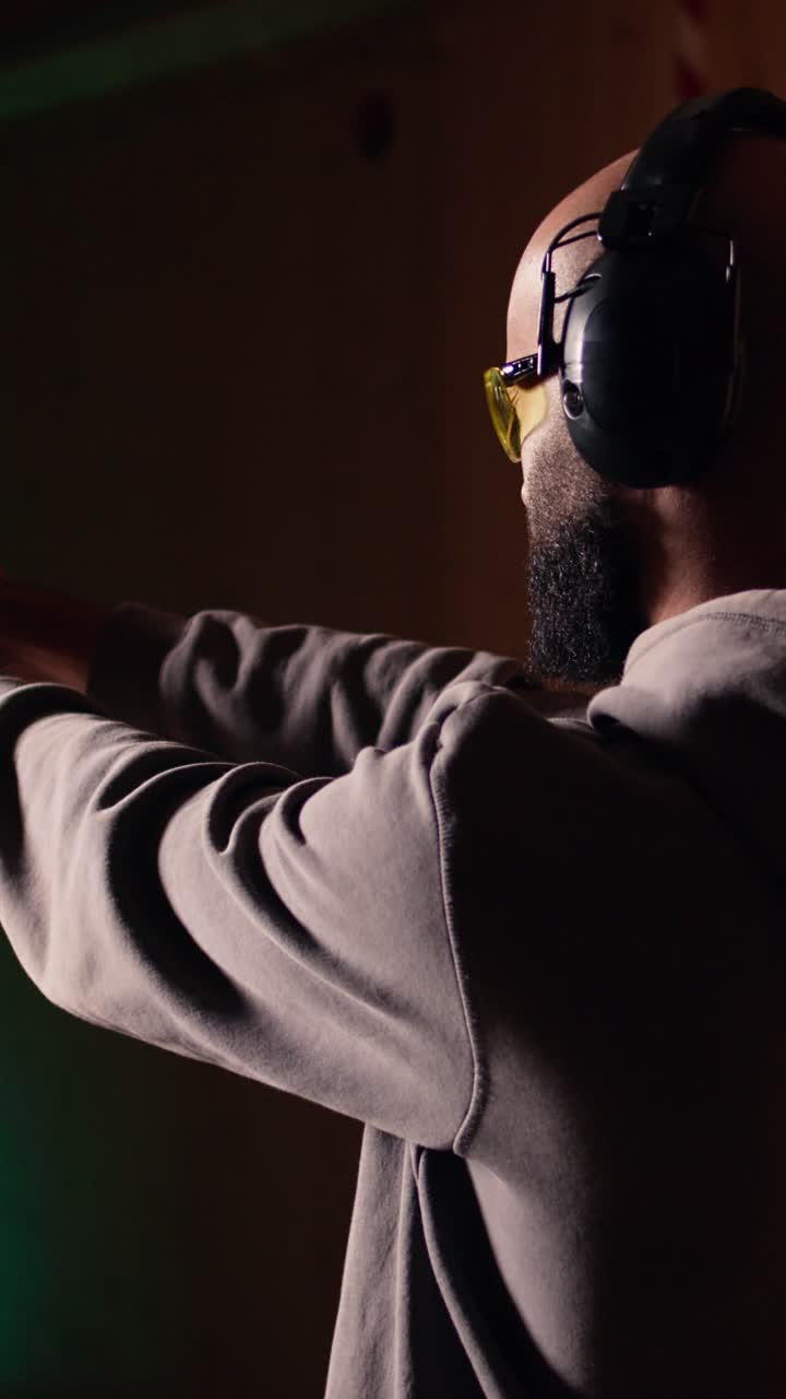 Vertical video Man shooting targets with pistol, learning to operate handgun in close quarters