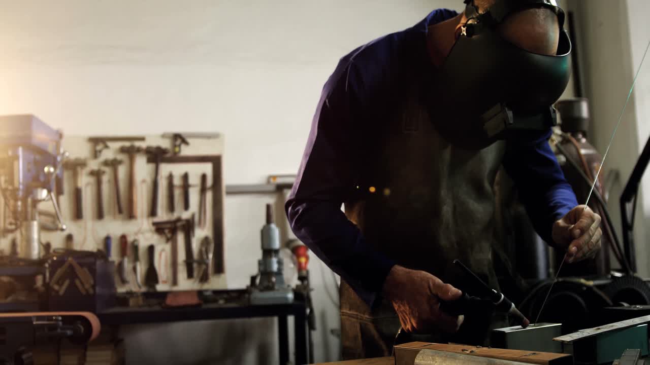 soldador masculino trabajando en una pieza de metal