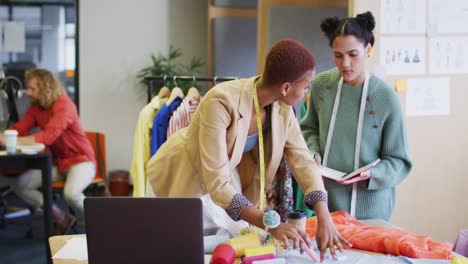 happy diverse business people discussing work with clothes at office