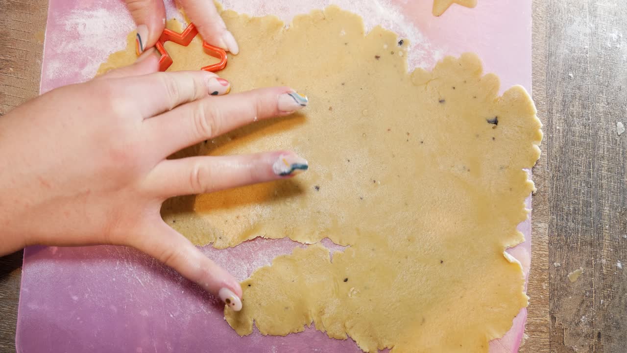 Nahaufnahme von oben: Eine weibliche Hand formt einen Lebkuchenstern