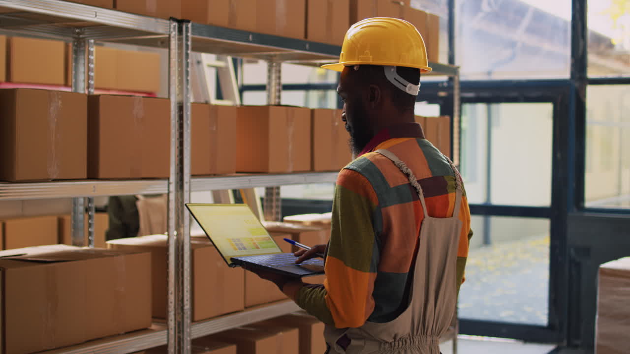 Warehouse Worker Using Laptop in Storage