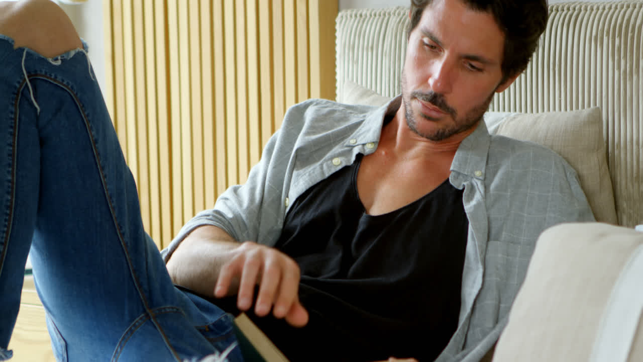 hombre leyendo una novela en la cama en el dormitorio 4k