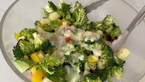 broccoli salad mixed with chopped vegetables, fruits, and nuts