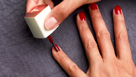 Mujer-Pintándose-Las-Uñas-Con-Esmalte-Rojo