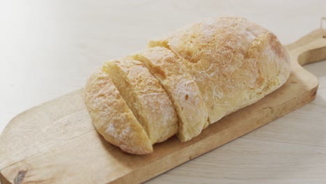 video of bread on chopping wooden board on wooden worktop