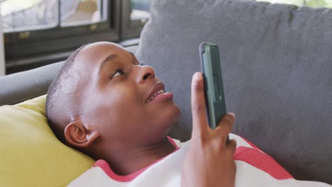 video of happy african american male teenage boy talking on smartphone, slow motion