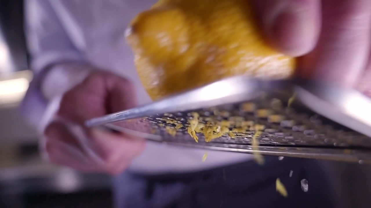 Uno chef che grattugia la scorza di limone al rallentatore