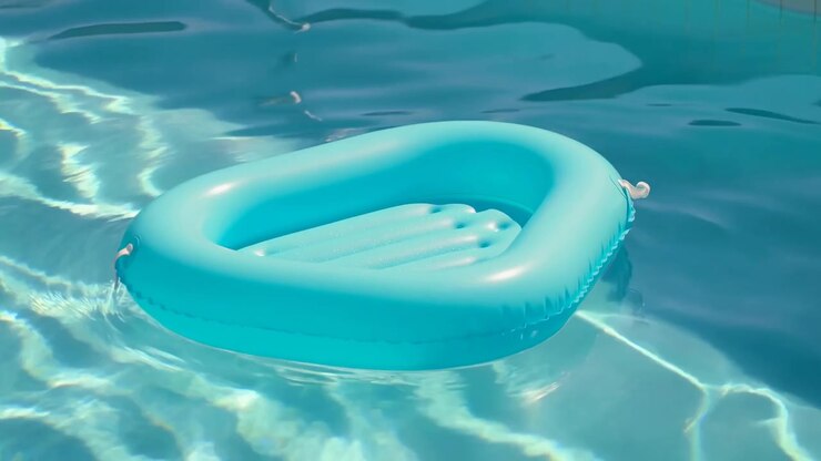 Inflatable ring floating in water floating and slight movement due to ripples, in clear blue water with light reflections, with inflatable ring, with inflatable material water texture.