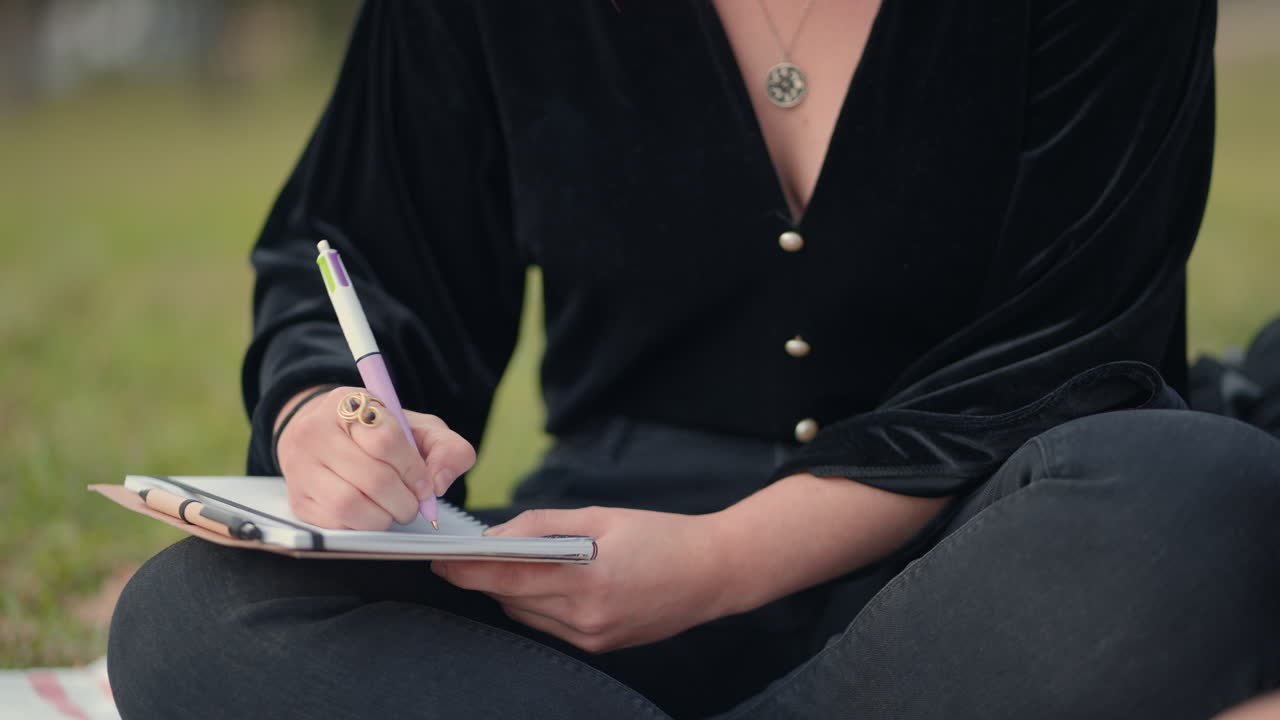 Woman writing in a notebook outdoors