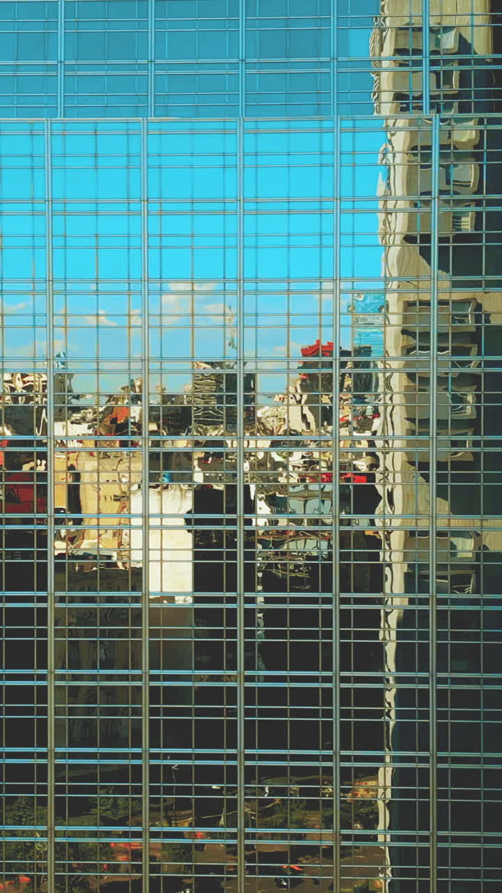 Reflexos da paisagem urbana na fachada de um arranha-céu moderno de vidro