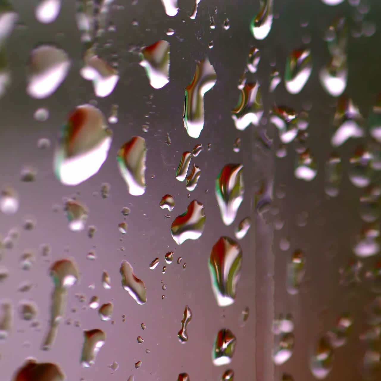 Rain drops on window. Water droplets falling on glass surface. Water drops falling. Selective focus video