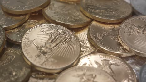 gold american eagles on a pile of silver american eagles spinning left