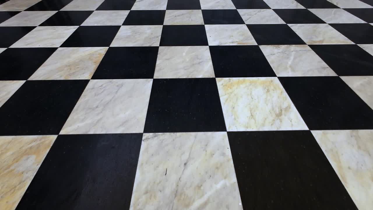 Motivo geometrico a scacchi bianchi e neri di pavimento in marmo.