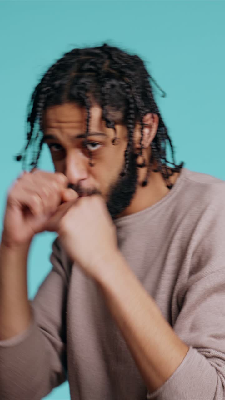 Vertical video Man throwing punches, holding defensive guard, studio background