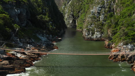 tourists crossing the suspension bridge over the storms river in tsitsikamma national park in south africa